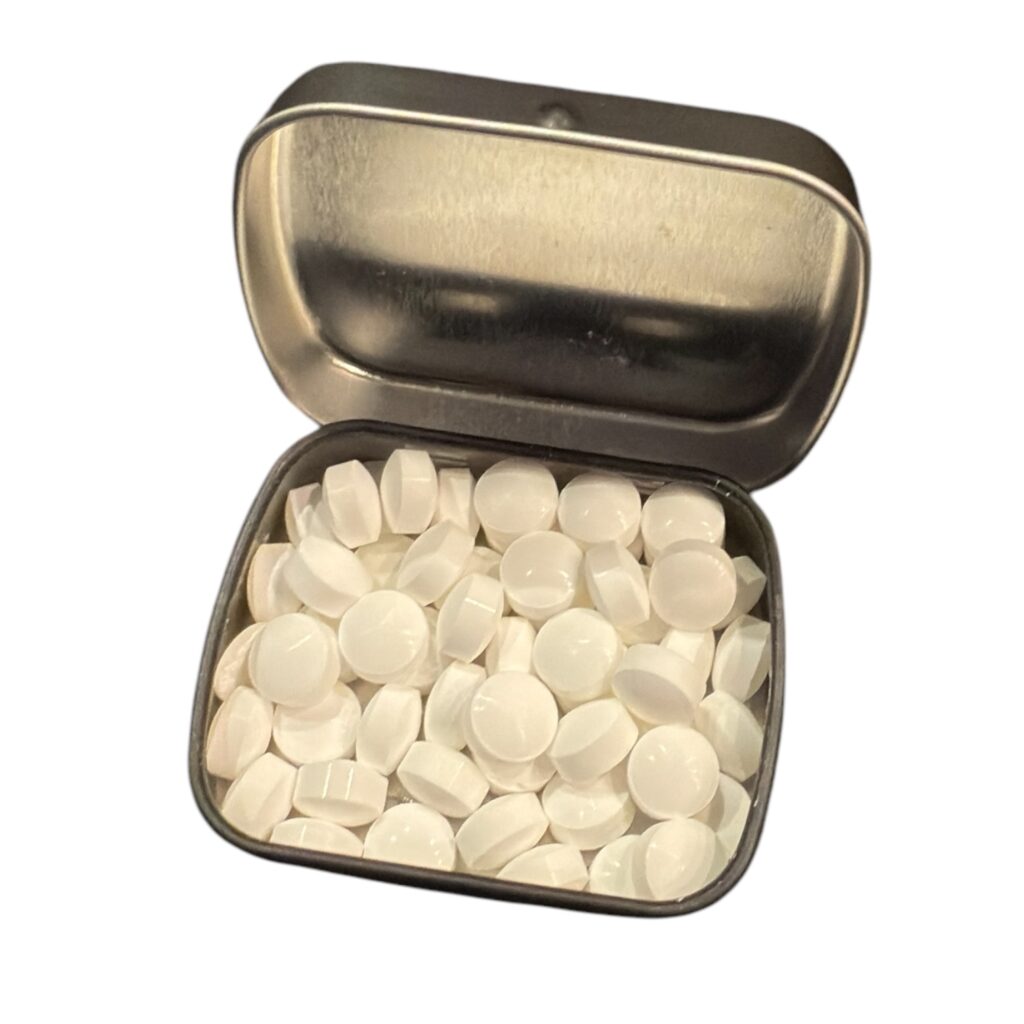 Metalen blikje met witte ronde tabletten