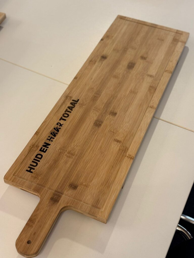 Houten snijplank met tekst 'HUID EN HAAR TOTAAL'